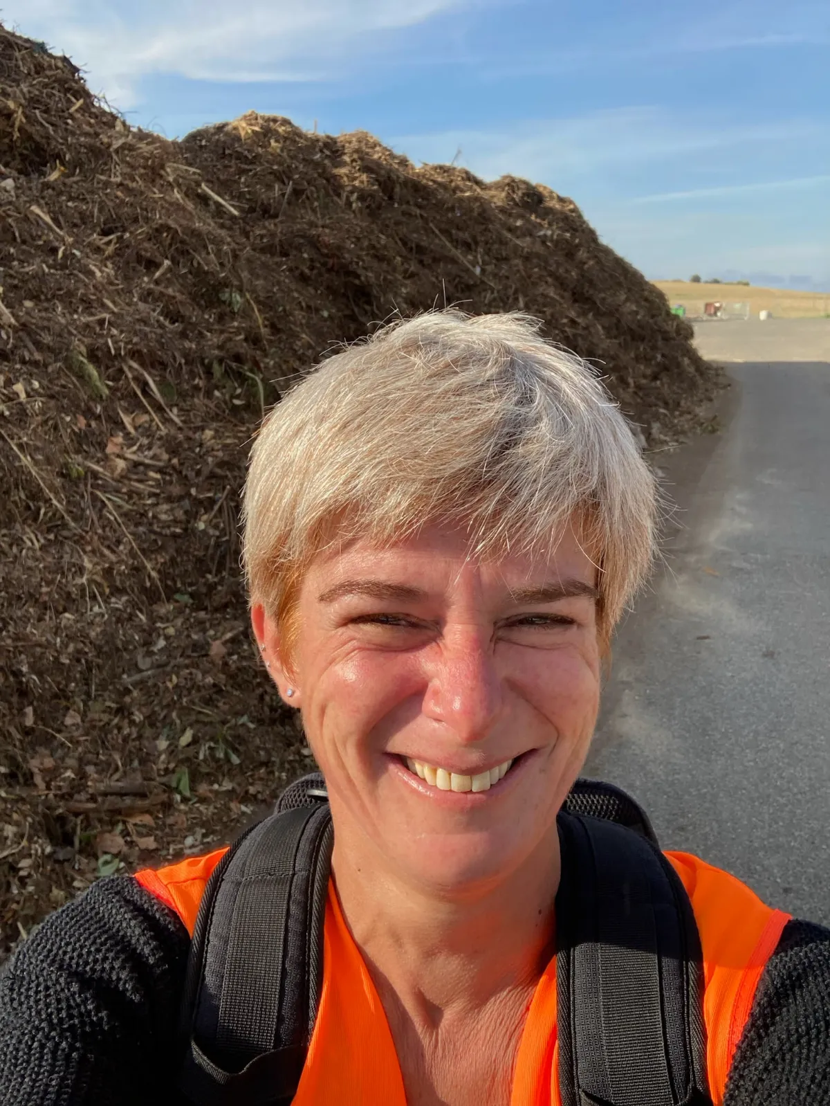 Portrait d'Anne-Laure Corniguel, maître composteur, devant un andain de compost