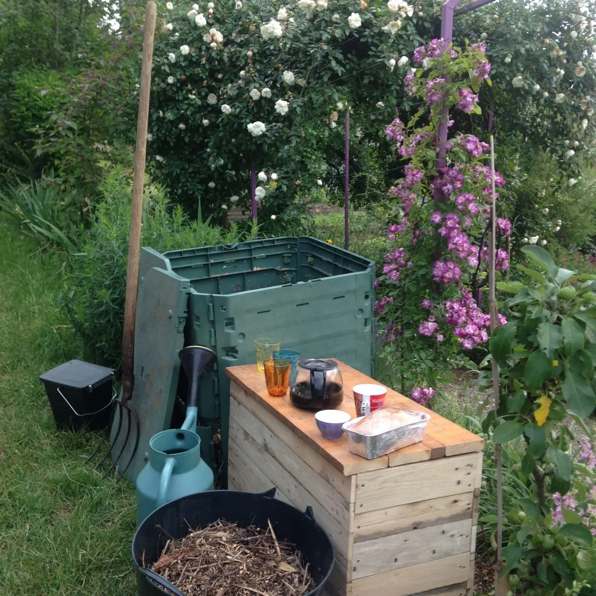 Café compost à côté d'un composteur dans un jardin partagé